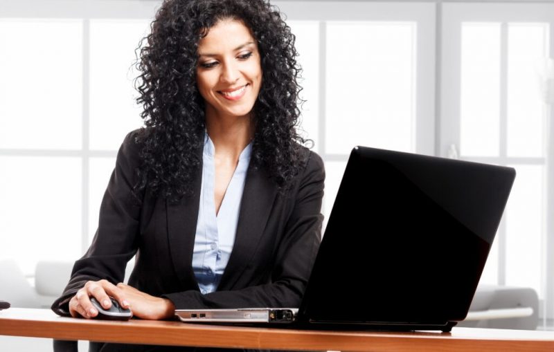Portrait,Of,A,Young,Smiling,Businesswoman,Using,Her,Computer